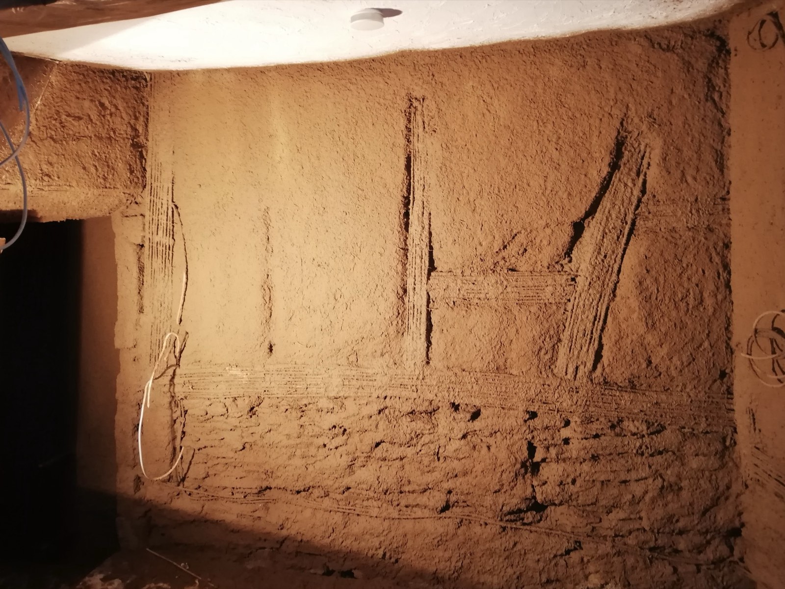 Frischer Lehmunterputz auf Innenwand mit sichtbaren Strohrohren, Fachwerkhaus Ahrtal