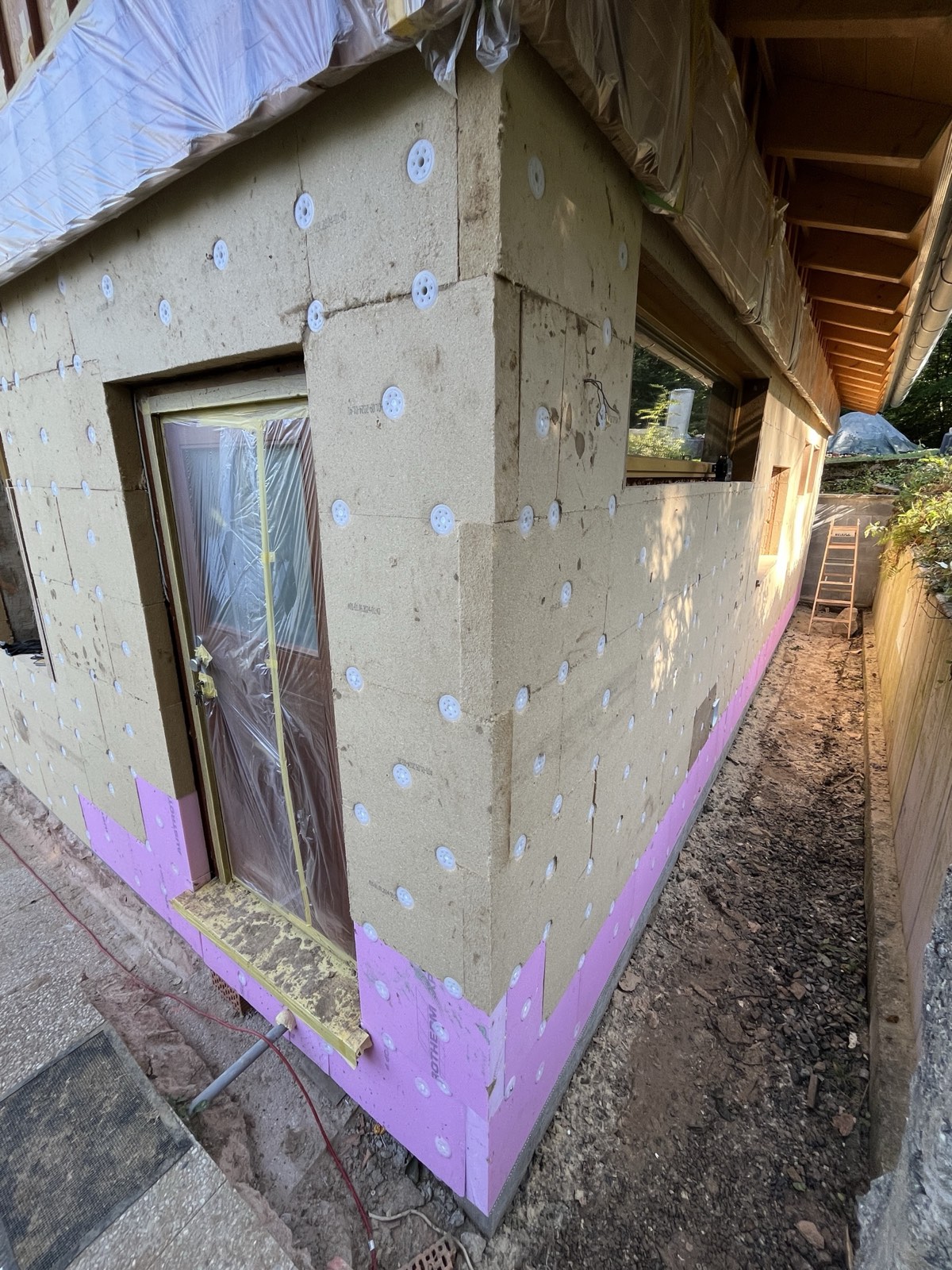 Holzfaserdämmplatten auf Fassade montiert: zwei Kellerfenster, Befestigungsscheiben