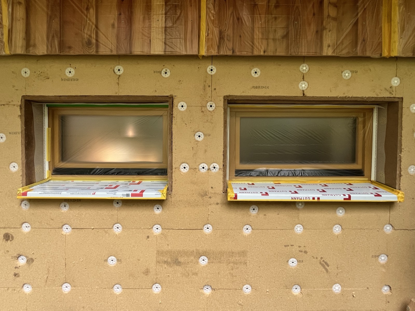 Kalkputz auf Holzfaserdämmung: Unterputzschicht aufgetragen, Kellerfenster integriert