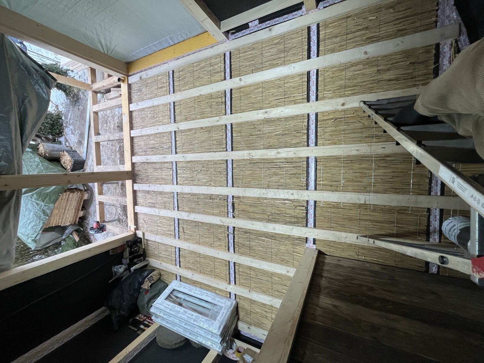 Gartenhaus-Fenstereinbau: neues Fensterelement mit Dichtung, Holzfassade außen