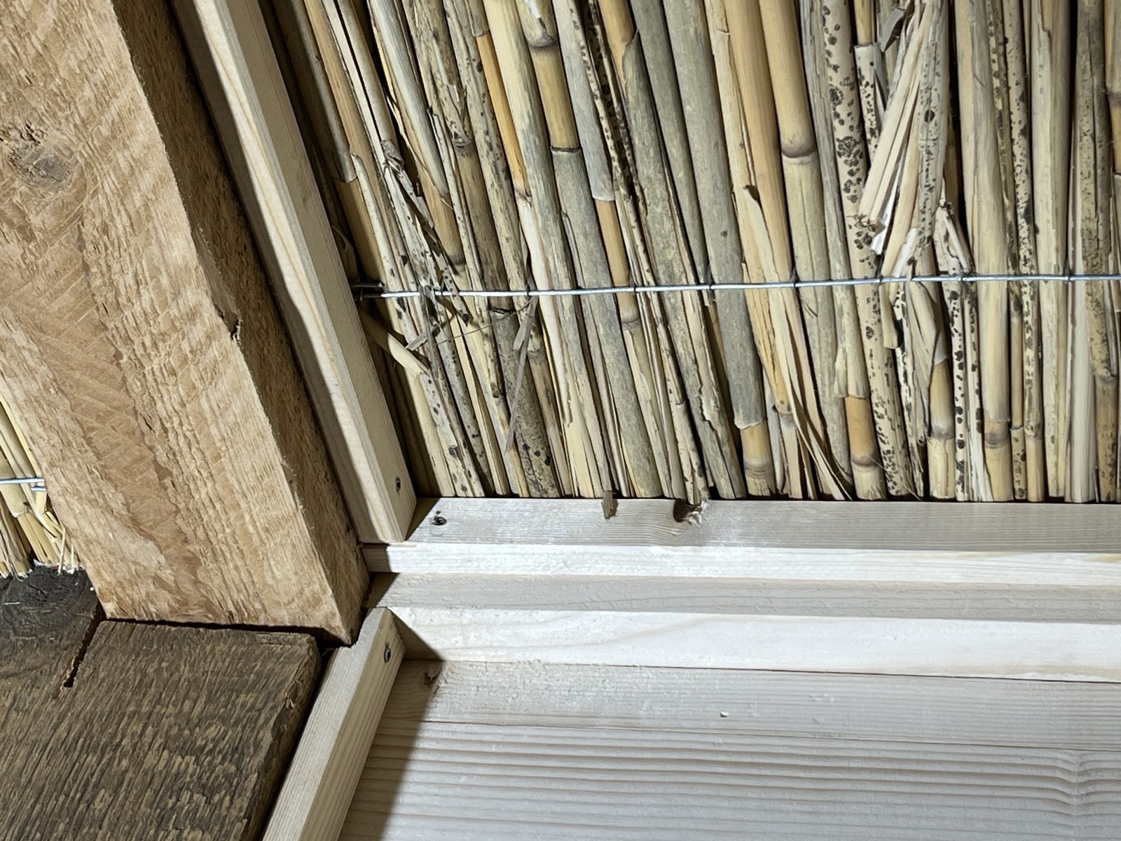 Gartenhaus-Innendetail: Holzdielenboden und Lehmputzwand im Übergang, Qualität