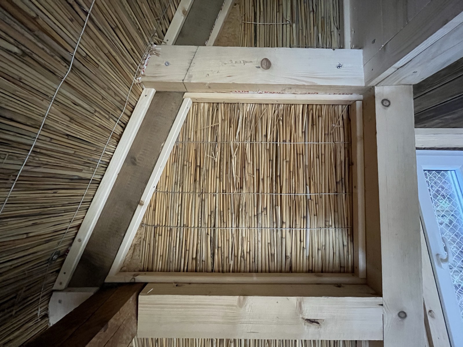 Gartenhaus-Dachdetail: Schilfrohrmatten-Einlage im Dachfensterrahmen, Holzkonstruktion