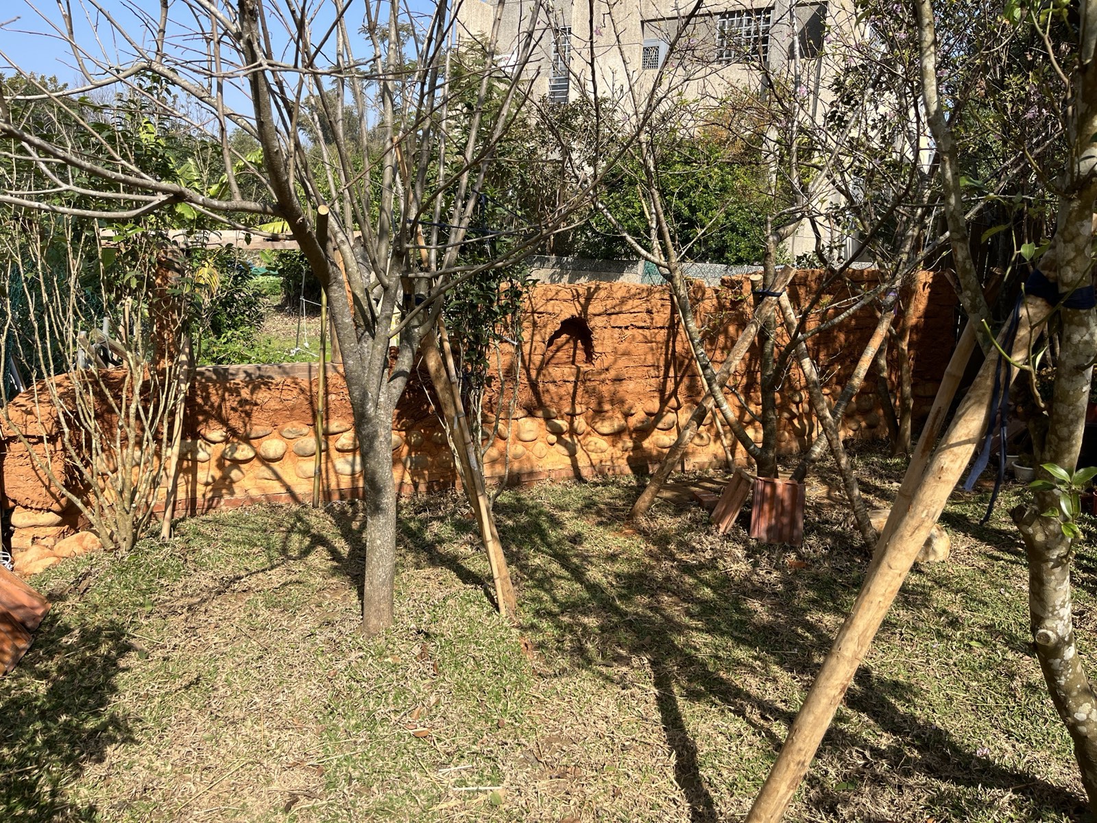 Lehmziegelmauer im Garten Taiwan, roter Ton mit Strohrissen, Bestand historisch