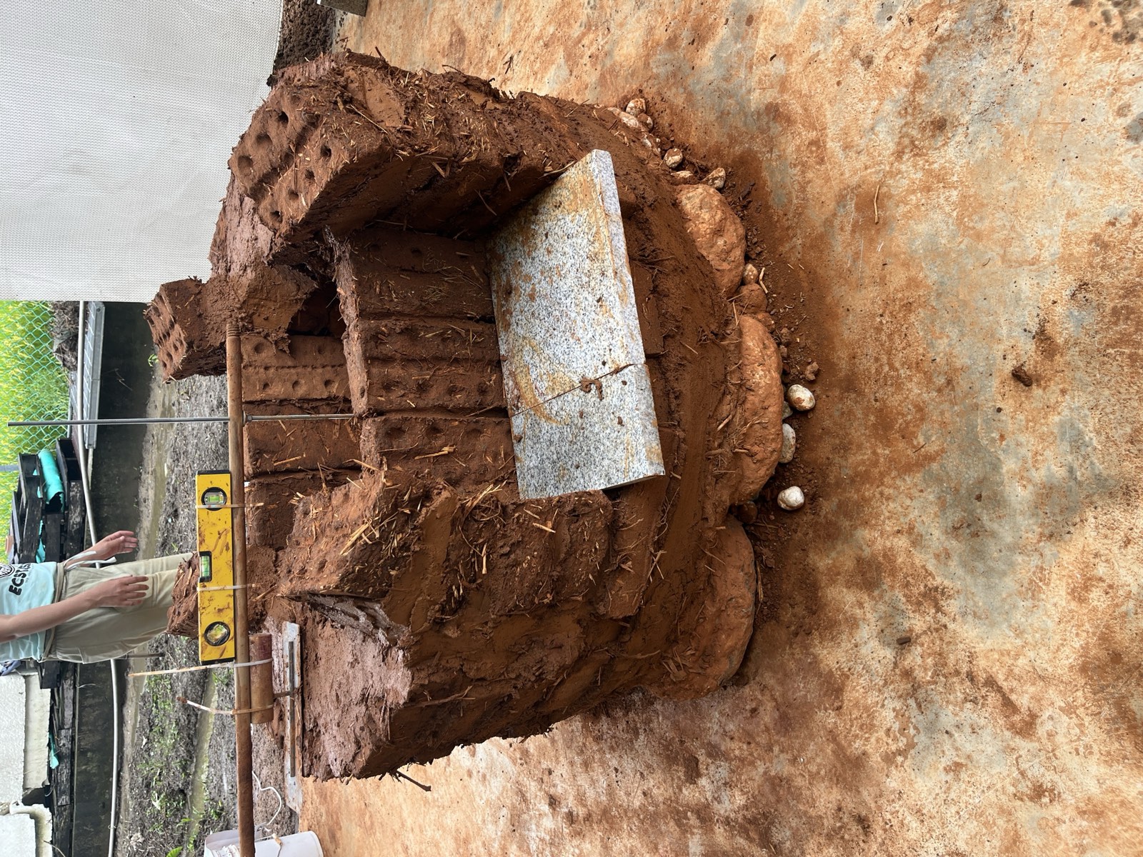 Lehmbackstein-Ofenbau im Rohbau: runde Form mit Ziegeln und Lehmverputz